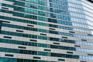 Fragment of a modern office building. Abstract geometric background. Part of a skyscraper with glass windows. photo
