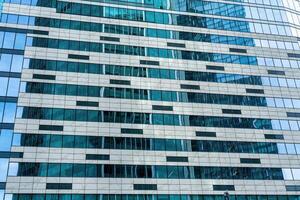 Fragment of a modern office building. Abstract geometric background. Part of a skyscraper with glass windows. photo