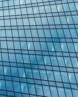 Fragment of a modern office building. Abstract geometric background. Part of a skyscraper with glass windows. photo