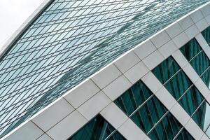 Fragment of a modern office building. Abstract geometric background. Part of a skyscraper with glass windows. photo