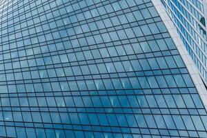 Fragment of a modern office building. Abstract geometric background. Part of a skyscraper with glass windows. photo