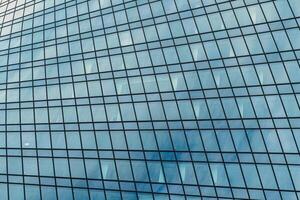 Fragment of a modern office building. Abstract geometric background. Part of a skyscraper with glass windows. photo