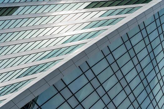 Fragment of a modern office building. Abstract geometric background. Part of a skyscraper with glass windows. photo