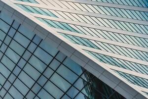 Fragment of a modern office building. Abstract geometric background. Part of a skyscraper with glass windows. photo