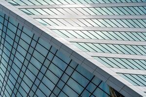 Fragment of a modern office building. Abstract geometric background. Part of a skyscraper with glass windows. photo