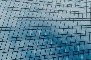 Fragment of a modern office building. Abstract geometric background. Part of a skyscraper with glass windows. photo