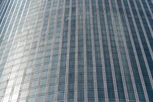 Fragment of a modern office building. Abstract geometric background. Part of a skyscraper with glass windows. photo