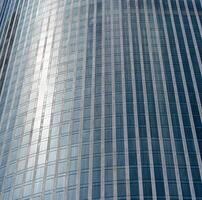 Fragment of a modern office building. Abstract geometric background. Part of a skyscraper with glass windows. photo