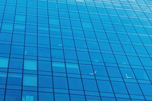 Fragment of a modern office building. Abstract geometric background. Part of a skyscraper with glass windows. photo