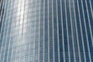 Fragment of a modern office building. Abstract geometric background. Part of a skyscraper with glass windows. photo