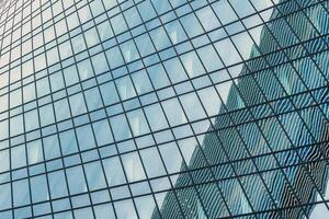 Fragment of a modern office building. Abstract geometric background. Part of a skyscraper with glass windows. photo