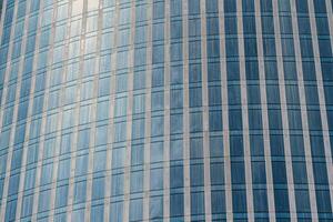 Fragment of a modern office building. Abstract geometric background. Part of a skyscraper with glass windows. photo
