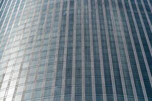 Fragment of a modern office building. Abstract geometric background. Part of a skyscraper with glass windows. photo