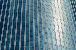 Fragment of a modern office building. Abstract geometric background. Part of a skyscraper with glass windows. photo