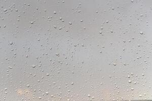 Raindrops on a window with a sunset sky in the background. photo