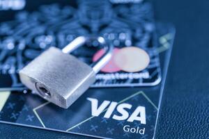 Russia, Kaluga - JULY 11, 2022 Debit or credit card with lock. The concept of security, protection or blocking of funds on the card. photo