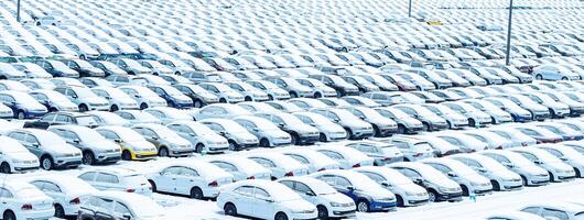 Volkswagen, Russia, Kaluga - NOVEMBER 11, 2022 New cars covered with a snow and parked in a distribution center, a car factory. photo