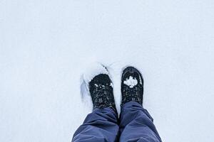 Legs in hiking boots for trekking in the snow. photo