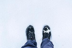 Legs in hiking boots for trekking in the snow. photo