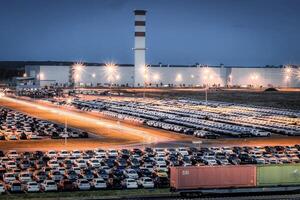 Volkswagen, Russia, Kaluga - JULY 14, 2022 New cars parked at distribution center automobile factory at night with lights. photo