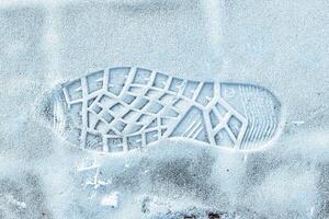Boot track on thin first snow in winter. photo