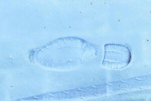 Boot track on thin first snow in winter. photo