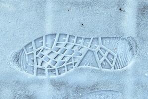 Boot track on thin first snow in winter. photo