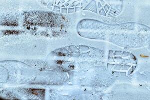 Boot track on thin first snow in winter. photo