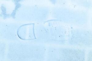 Boot track on thin first snow in winter. photo