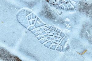 Boot track on thin first snow in winter. photo