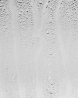 Rain drops on window glasses surface with gray sky background . Natural backdrop of raindrops. Overlay for design. The concept of bad rainy weather. photo
