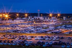 Volkswagen, Russia, Kaluga - AUGUST 26, 2020 New cars parked at distribution center automobile factory at night with lights. Parking on the open air. photo