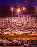 Volkswagen, Russia, Kaluga - AUGUST 26, 2020 New cars parked at distribution center automobile factory at night with lights. Parking on the open air. photo
