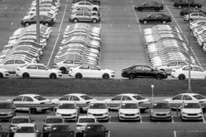 Volkswagen Group Rus, Russia, Kaluga - MAY 24, 2020 Rows of a new cars parked in a distribution center on a day in the spring, a car factory. Parking in the open air. Black and white photo. photo