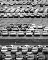 Volkswagen Group Rus, Russia, Kaluga - MAY 24, 2020 Rows of a new cars parked in a distribution center on a day in the spring, a car factory. Parking in the open air. Black and white photo. photo