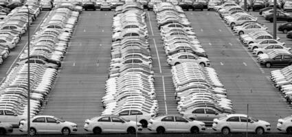 Volkswagen Group Rus, Russia, Kaluga - MAY 24, 2020 Rows of a new cars parked in a distribution center on a day in the spring, a car factory. Parking in the open air. Black and white photo. photo