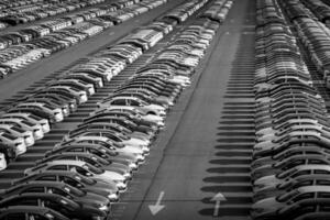 Volkswagen Group Rus, Russia, Kaluga - MAY 24, 2020 Rows of a new cars parked in a distribution center on a day in the spring, a car factory. Parking in the open air. Black and white photo. photo