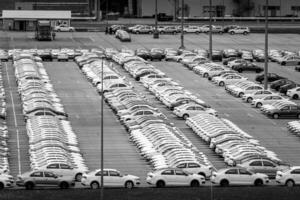 Volkswagen Group Rus, Russia, Kaluga - MAY 24, 2020 Rows of a new cars parked in a distribution center on a day in the spring, a car factory. Parking in the open air. Black and white photo. photo