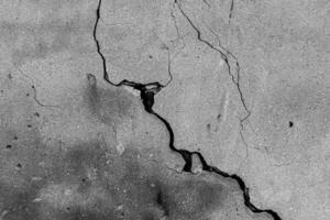 Black and white texture of a concrete wall with a crack. photo