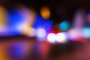Blurred lights of headlights of cars and lanterns in the night city. Abstract bokeh. photo