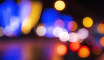 Blurred lights of headlights of cars and lanterns in the night city. Abstract bokeh. photo