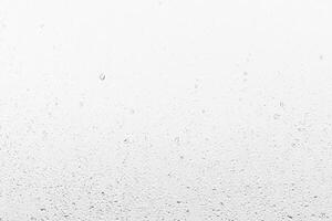 Rain drops on window glasses surface with gray sky background . Natural backdrop of raindrops. Abstract overlay for design. The concept of rainy weather. photo