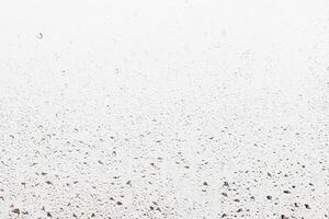 Rain drops on window glasses surface with gray sky background . Natural backdrop of raindrops. Abstract overlay for design. The concept of rainy weather. photo