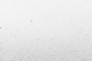 Rain drops on window glasses surface with gray sky background . Natural backdrop of raindrops. Abstract overlay for design. The concept of rainy weather. photo