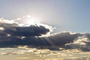 Sun rays breaking through cumulus clouds. The concept of divine light, a glimmer of hope or overcoming difficulties. Spiritual religious background. photo