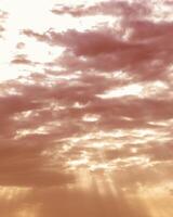 Sun rays breaking through cumulus clouds. The concept of divine light, a glimmer of hope or overcoming difficulties. Spiritual religious background. photo