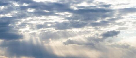 Sun rays breaking through cumulus clouds. The concept of divine light, a glimmer of hope or overcoming difficulties. Spiritual religious background. photo