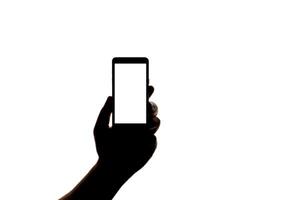Silhouette of hand with smartphone taking picture isolated on white background. Screen with copy space. Blank for design. photo