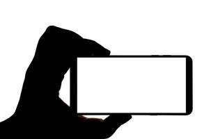 Silhouette of hand with smartphone taking picture isolated on white background. Screen with copy space. Blank for design. photo