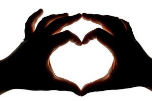 Silhouette of hands showing heart gesture isolated on white background. Blank for design. photo